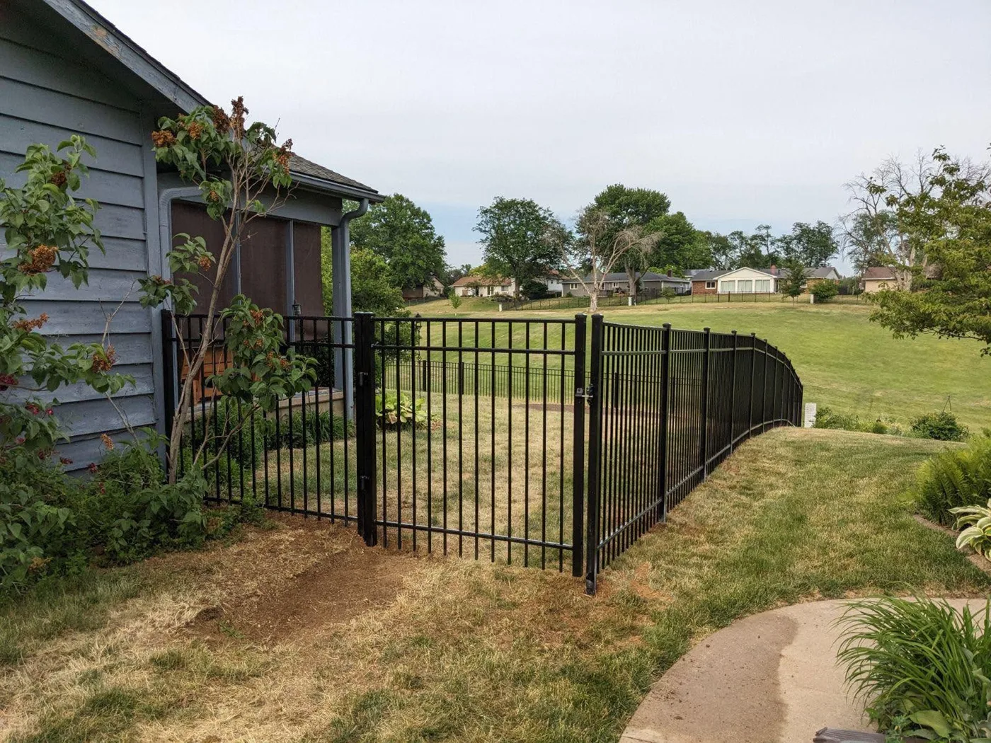 Black aluminum fence installed around a residential yard in Central Illinois