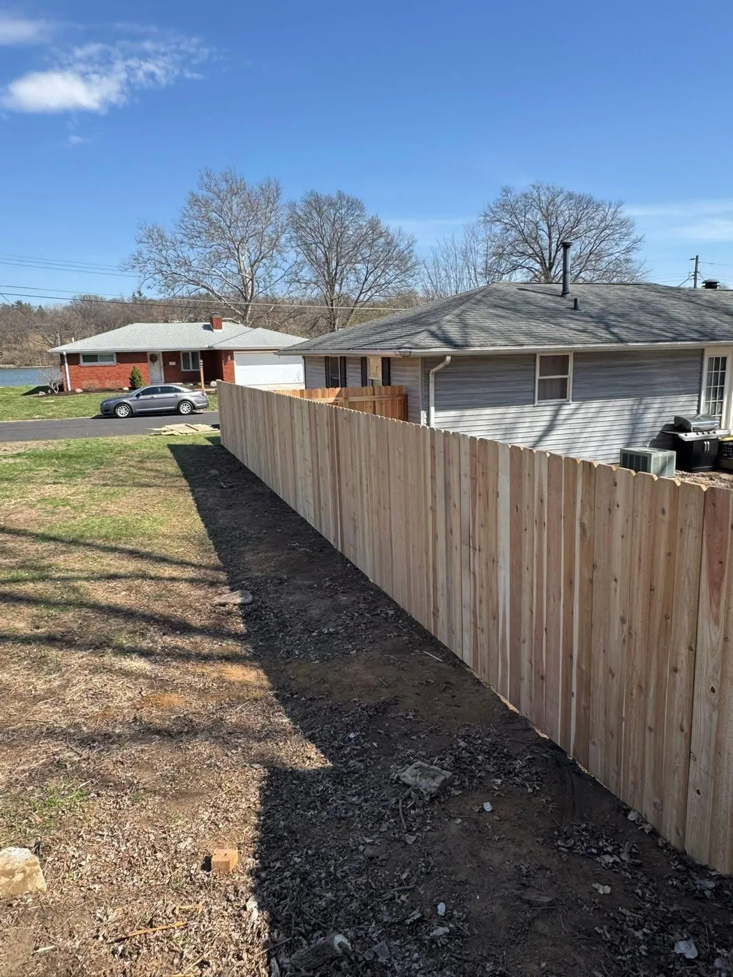 New wood privacy fence line installed along a property boundary in Pekin, IL